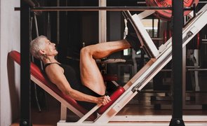 mulher fazendo legpress na academia